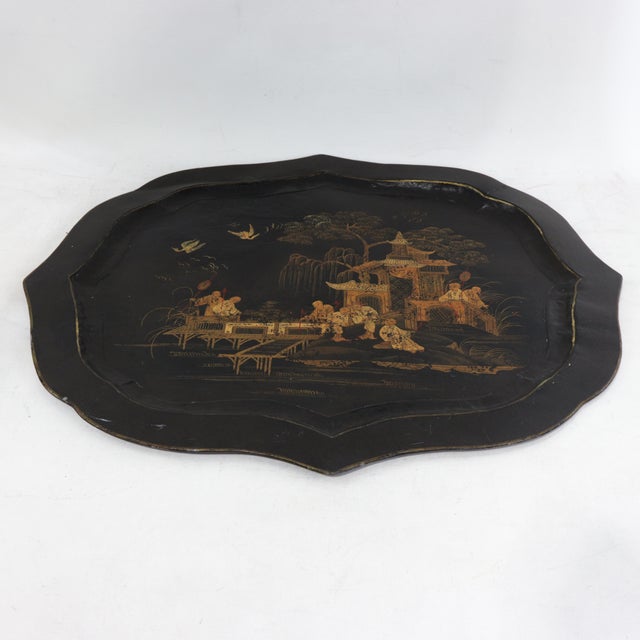 This exquisite vintage tole tray features a unique scalloped and lobed silhouette finished in a deep black lacquer with...