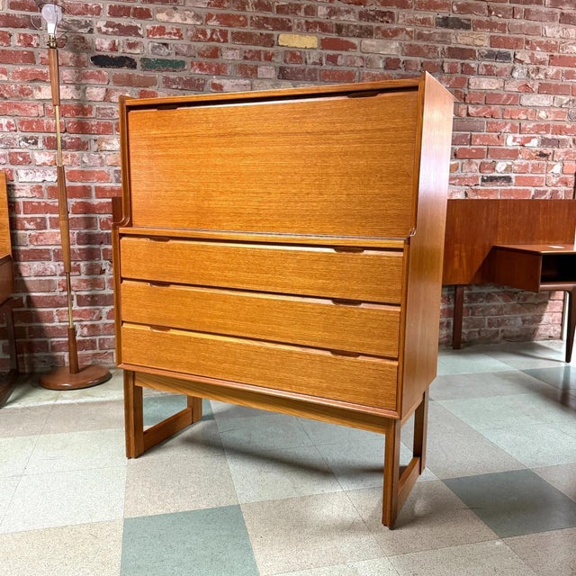 Vintage mid-century modern teak drop-front secretary desk or drinks cabinet manufactured by Turnidge of London. The...