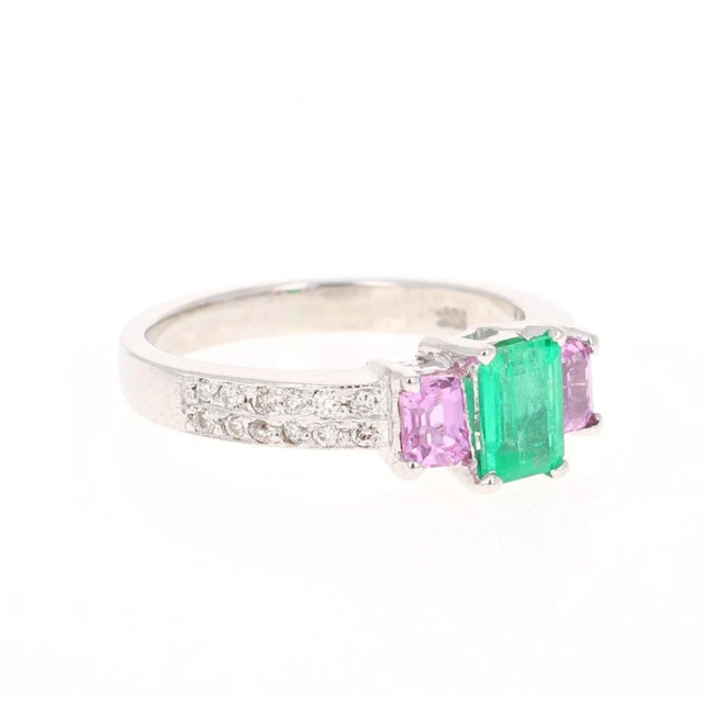 This ring has an Emerald Cut Green Emerald that weighs 0.65 Carats with 2 Emerald Cut Pink Sapphires on each side that...