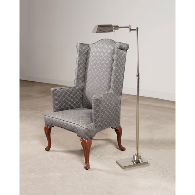 A sleek steel frame with a polished nickel finish pharmacy-style floor lamp featuring a hooded metal shade. Made in the...