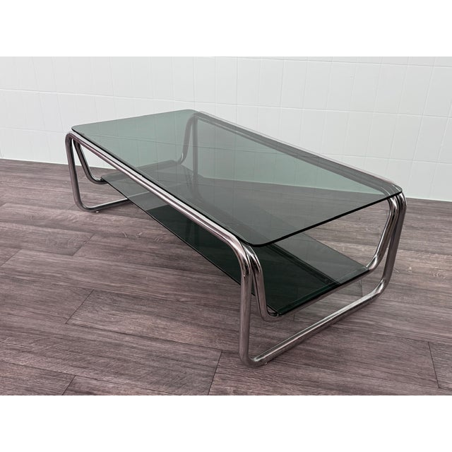 Vintage coffee table with a chromed tubular frame and double smoked glass shelves, very popular in Italian design of the...
