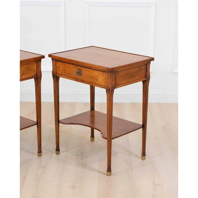 Made in France in the twentieth century, this pair of Louis XVI style tables is constructed in cherrywood, each with a...