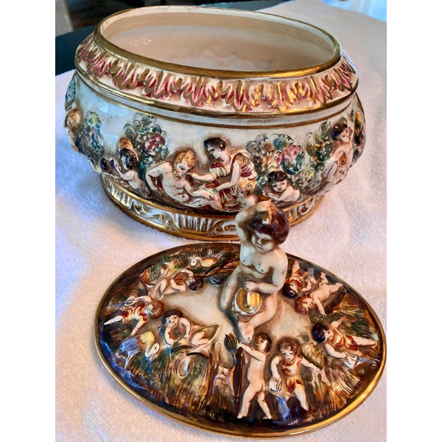 Signed vintage Capodimonte Italy oval porcelain bowl/ centerpiece with fitted lid. Raised and gilded motif with cherubs in...