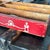 Hand-crafted wooden cutlery tray featuring a vibrant red exterior and stenciled folk art figures. The interior features...