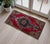 This striking vintage Anatolian rug features a vibrant crimson red field anchored by a distinctive geometric central...