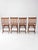 This set of four antique wood folding chairs features slatted wood seats, tall vertical-slat backs, and warm aged...