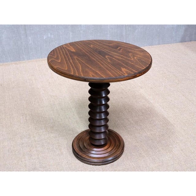 This rare side table was designed by Charles Dudouyt and produced in France in the late 1940s. The different carved shapes...