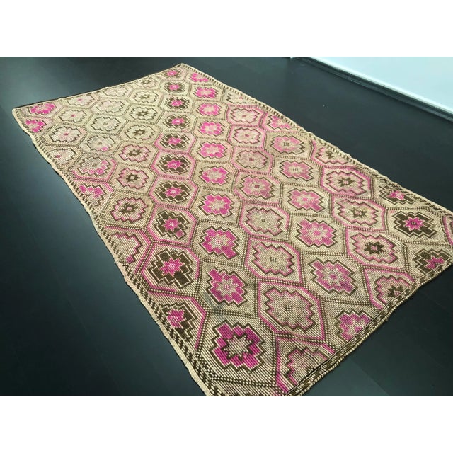 This is a vintage Turkish wool kilim rug. The piece was handmade in the 1960s.