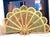 Vintage brass fireplace screen featuring an ornate peacock fan silhouette with intricate pierced detailing and a dramatic...