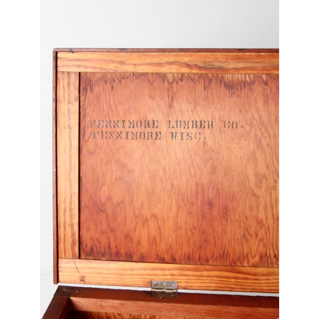 This large vintage wooden crate features Fennimore Lumber Co. branding on the inside of its hinged lid. Set on casters...