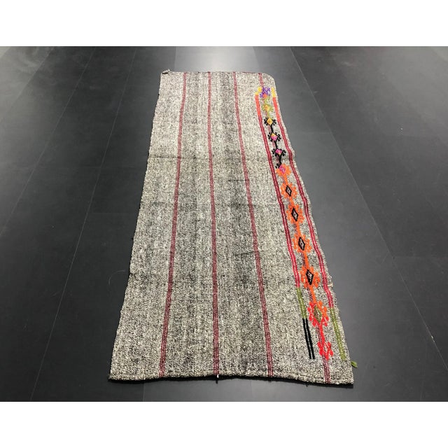 This is a vintage Turkish Kilim rug. The piece was handmade in the 1960s.