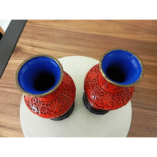 Offered are a stunning pair of vintage mid-century Chinese cinnabar lacquer vases featuring a vibrant red hue. These vases...