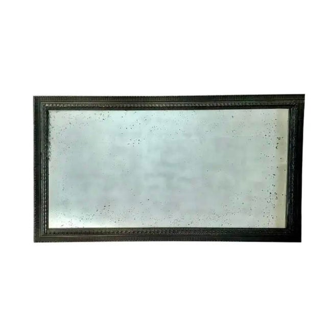 Monumental Dutch Wall Mirror featuring a deeply ripple carved and ebonized wood frame with dimensional detailing and aged...