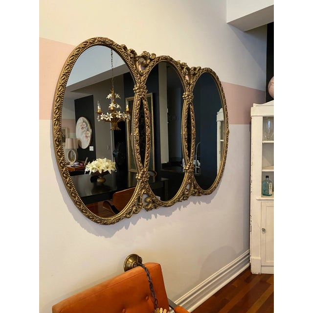 Large Gilded Triple-Oval Mirror with Faux Marble Inlay A magnificent statement mirror featuring three oval panels framed...