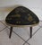 Tripod side table from the 1960s. Wooden compass legs. Guitar pick-shaped top with a gold Japanese-inspired design on a...
