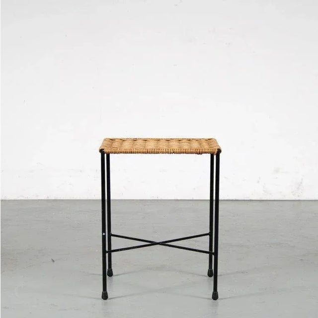 A beautiful minimalist stool, made of thin black lacquered tubular metal and a wicker seat / top. The wicker and metal...