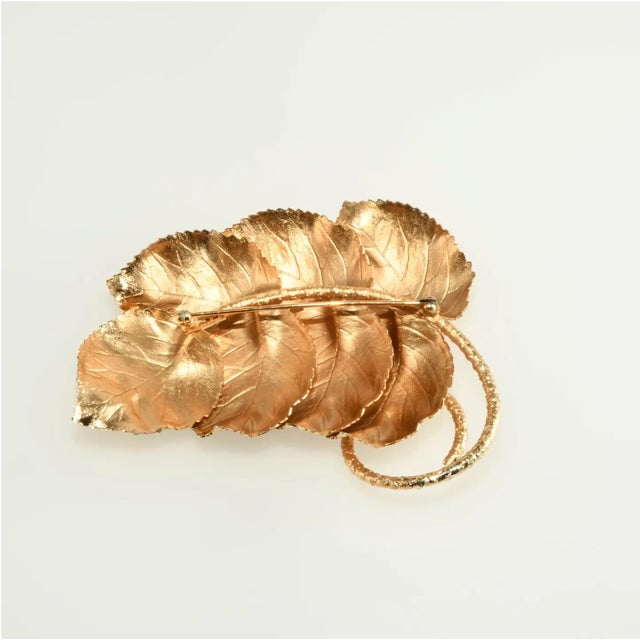 Vintage costume jewelry brooch crafted to look like a large spray of leaves. Metal is gold-plated with textured finish on...