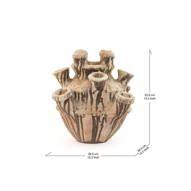 Multiple open spouts rise like a small skyline from the shoulders of this Tamegroute vessel, its wide, robust base marked...