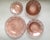 A charming set of pink pressed glass dishes featuring a floral center bordered with lines and leaves. Bowl #1(cereal...