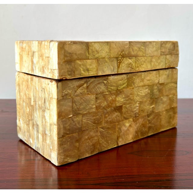 This elegant decorative box features a lustrous mosaic exterior composed of square-cut tiles in varying shades of warm,...