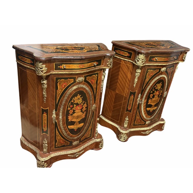 A striking pair of circa 1800s Napoleon III style marquetry cabinets, beautifully crafted with intricate inlay and elegant...