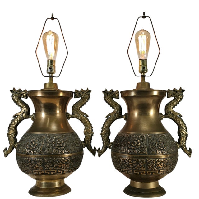 A striking matched pair of repoussé brass table lamps in the Hollywood Regency taste, inspired by the celebrated designs...