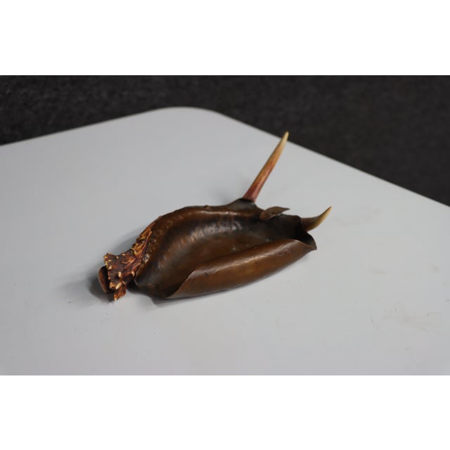 Antique copper ashtray by Berry & Co., featuring a hand-hammered bowl with a sculptural deer antler handle and natural...