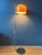 A very rare guzzini forma floor lamp featuring a striking orange shade that can be moved and positioned to direct the...