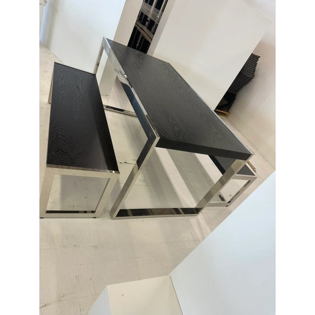 A playful take at a picnic table and benches, this sophisticated chrome and wood set makes a statement in your home. two...