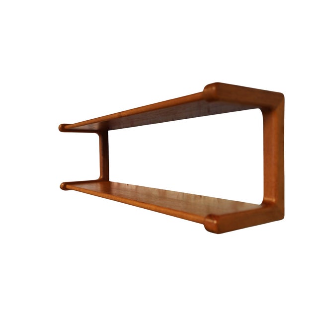 A very unusual and well-made teak wall shelf from the Danish company Dyrlund. Softly shaped ends, rounded edges and the...