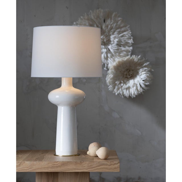 Enhance your space with the Sabina Table Lamp, a modern marvel with a distinctive silhouette. The lamp features a ceramic...