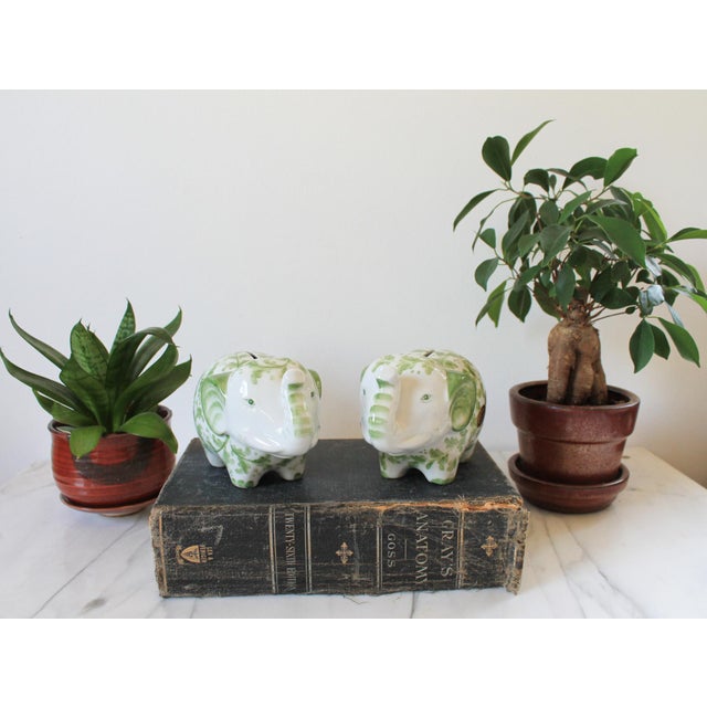 Pair of green and white ceramic elephant banks. Makers mark on the side of each piece. Andrea by Sadek. Made in Thailand....