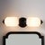 This elegant wall sconce features two white glass shades with a detailed black metal base and end caps. Perfect for...