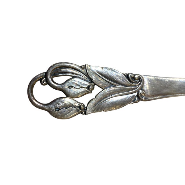 A refined Danish silver-plate serving set by Axel Prip, featuring a spoon and matching two-tine fork with sculptural,...