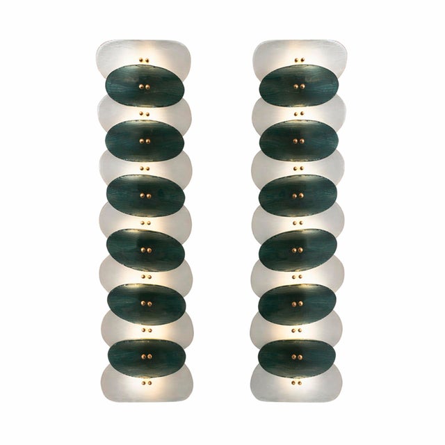 Sculptural pair of murano glass and brass wall sconces, composed of vertically stacked oval elements creating a refined...