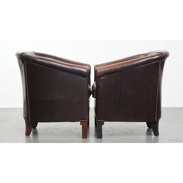 Offered is this elegant and comfortable set of 2 cowhide leather club chairs in English style in a beautiful dark color....