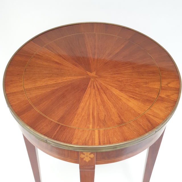 Louis XVI style pedestal table 1960-1970 featuring a marquetry inlaid top. Brass rim and base. Brass feet. Signs of wear...