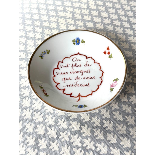 Limoges porcelain cachepot. Handpainted flowers around the sides, gilded edges and center French saying.
