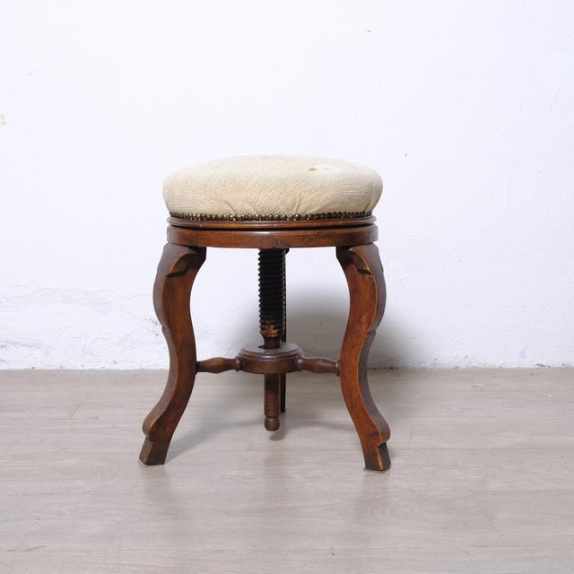 A beautiful 19th-century piano stool, it features a padded swivel seat with height adjustment via a central screw....