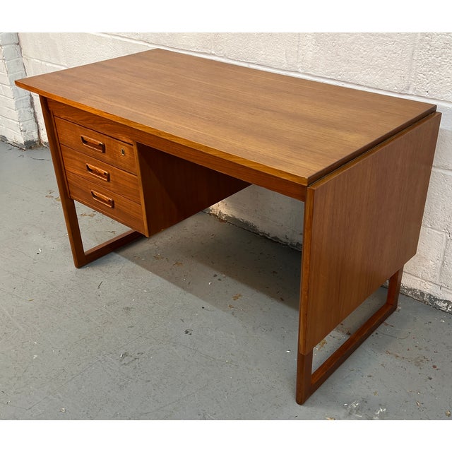 Discover the perfect blend of form and function with this 1960s Danish extending drop-leaf teak desk, a versatile piece...