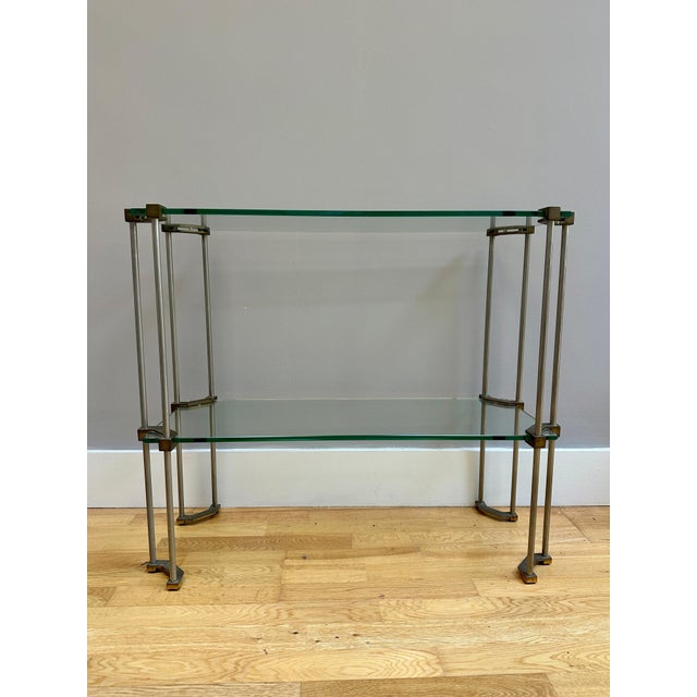 A brass and glass two tier console or etagere by Peter Ghyczy. Typical thick glass plates. Stamped on each brass...