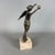 A slender freestanding figurative sculpture depicting Winged Victory (Nike), attributed to 20th-century craftsmanship....