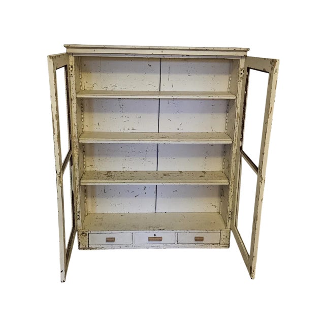 A charming and characterful antique French glazed vitrine bookcase in heavily distressed white painted finish. The double...