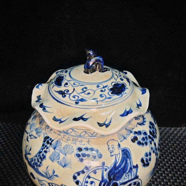Remarkable Chinese blue and white porcelain jar topped with a ruffled lotus-leaf shaped lid crowned by a sculpted finial....