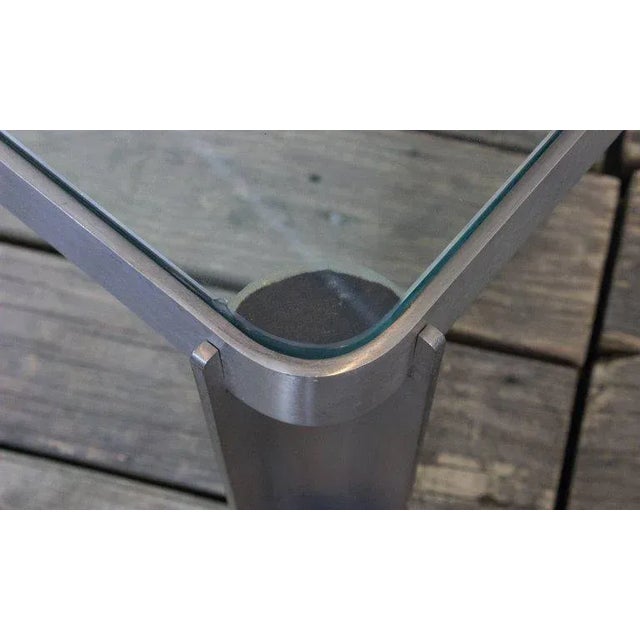 This vintage coffee table, originating from France in the 1980s, features a brushed aluminum and glass construction that...