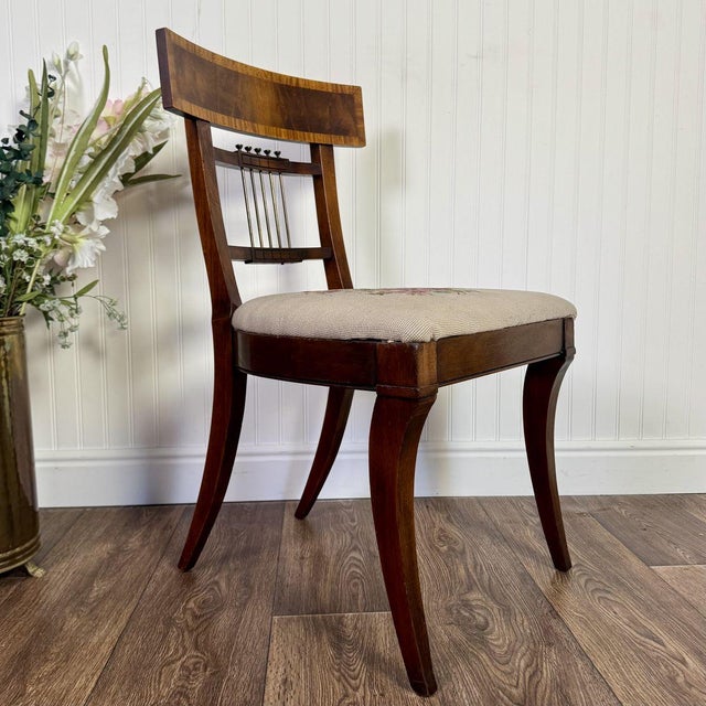 Lovely vintage accent chair with a floral needlepoint design on the upholstered seat. The back features a crest rail with...