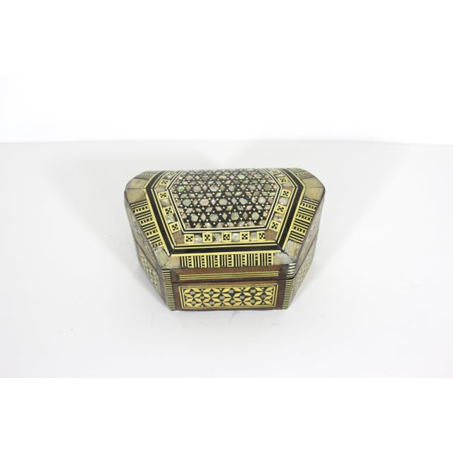 Vintage humpback wood trinket box with inlaid mother of pearl and bone detail. The shell is iridescent and beautiful. The...