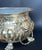Elegant antique brass jardiniere featuring finely detailed lion head handles with suspended ring pulls and a richly...