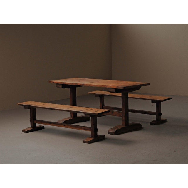 Set comprises a rectangular dining table and its matching pair of benches, crafted from solid pine in France in the 1970s....