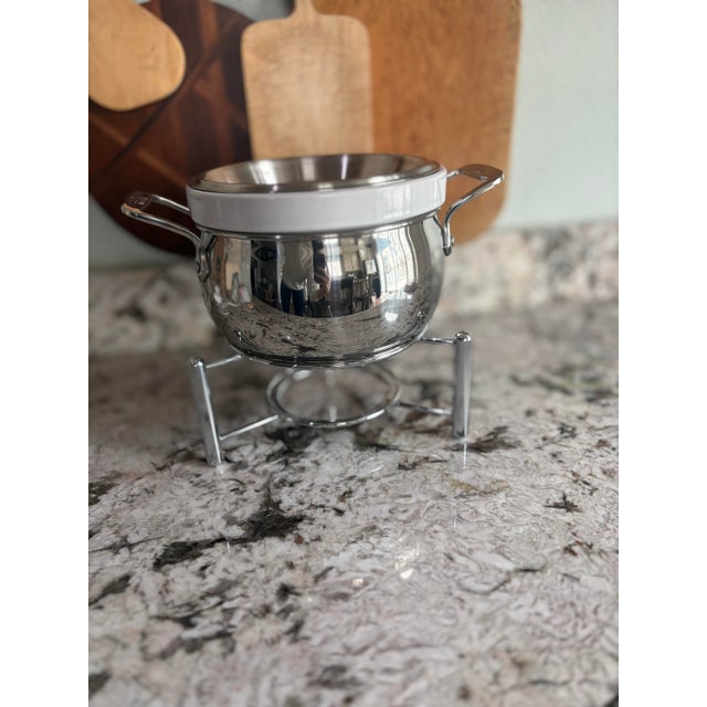 An elegant tabletop entertaining piece by All-Clad featuring a polished stainless steel warmer with removable porcelain...